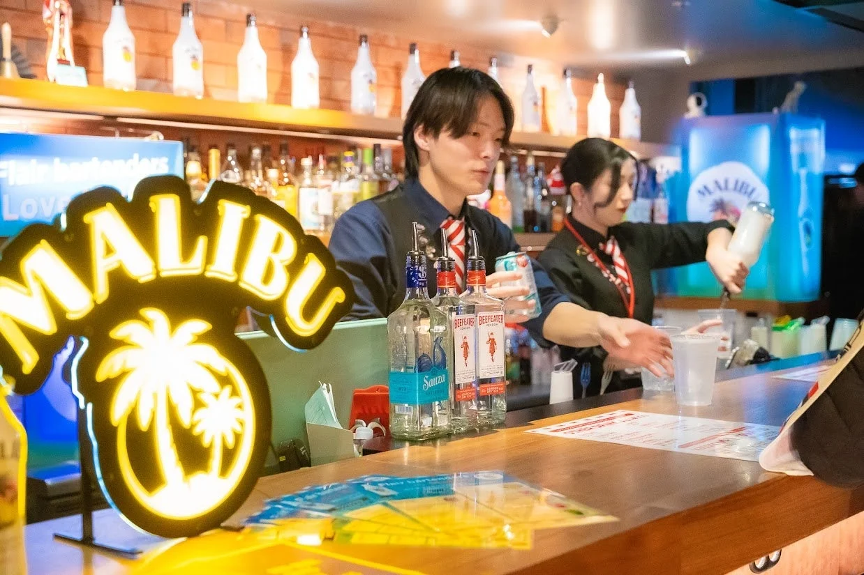 バーカウンターでカクテルを作るバーテンダー