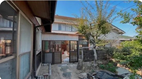 青空の下、庭のある二階建ての古民家