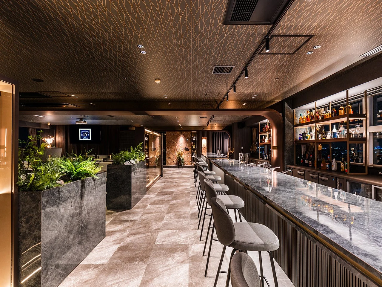 都会的な夜景が見える、モダンでラグジュアリーなバーの内部