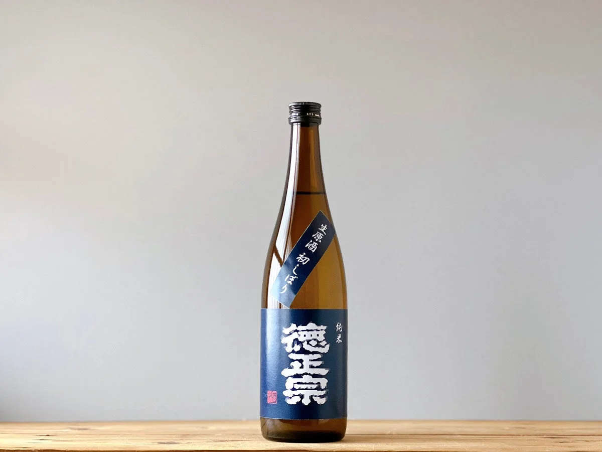 木製のテーブルに置かれた徳正宗 純米 初しぼり生原酒のボトル。