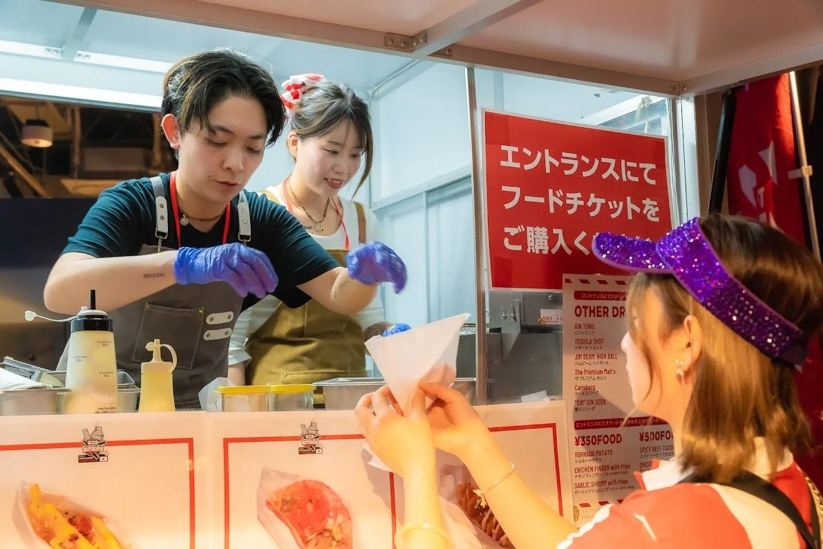 フードトラックで料理を提供するスタッフ