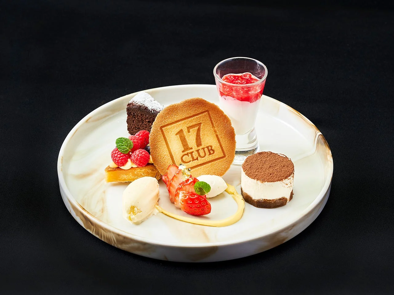 様々な種類のデザートが美しく盛り付けられた白いプレート