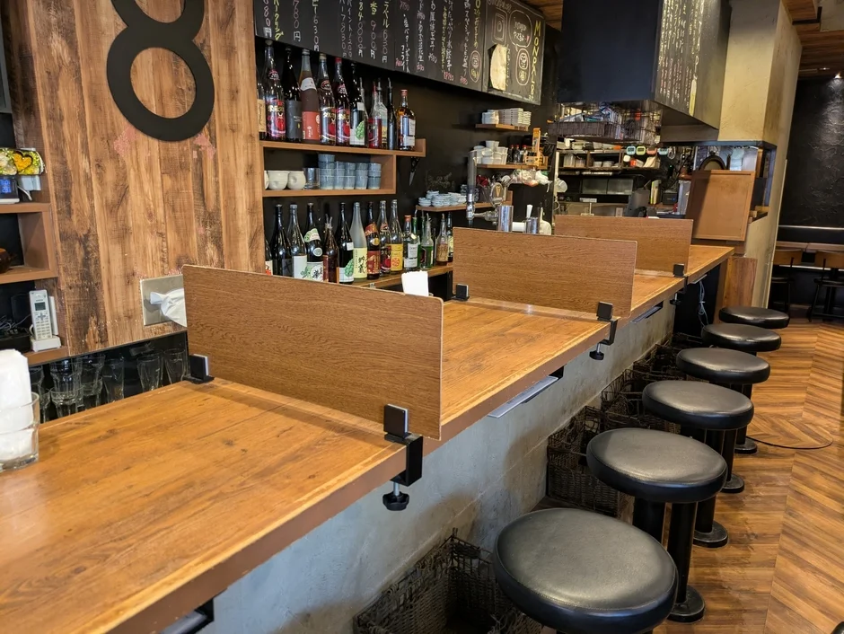 木製のカウンター席が並ぶ居酒屋の店内