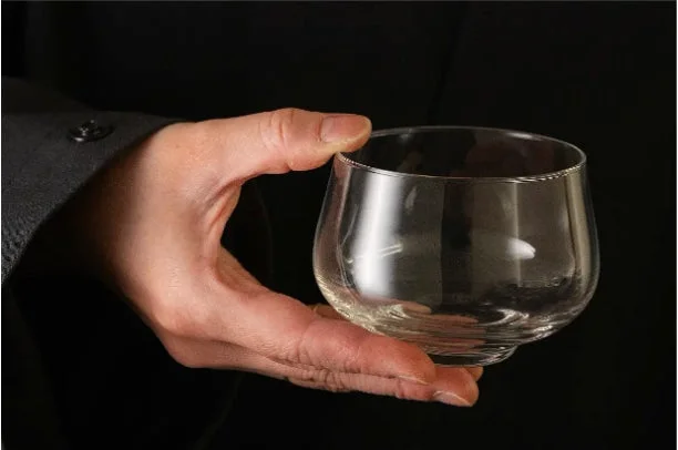 手がグラスを持っている