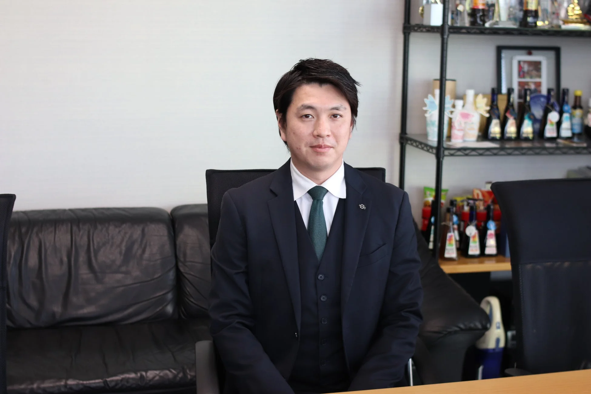 紺色のスーツを着たオリバーソース株式会社の道満龍彦社長