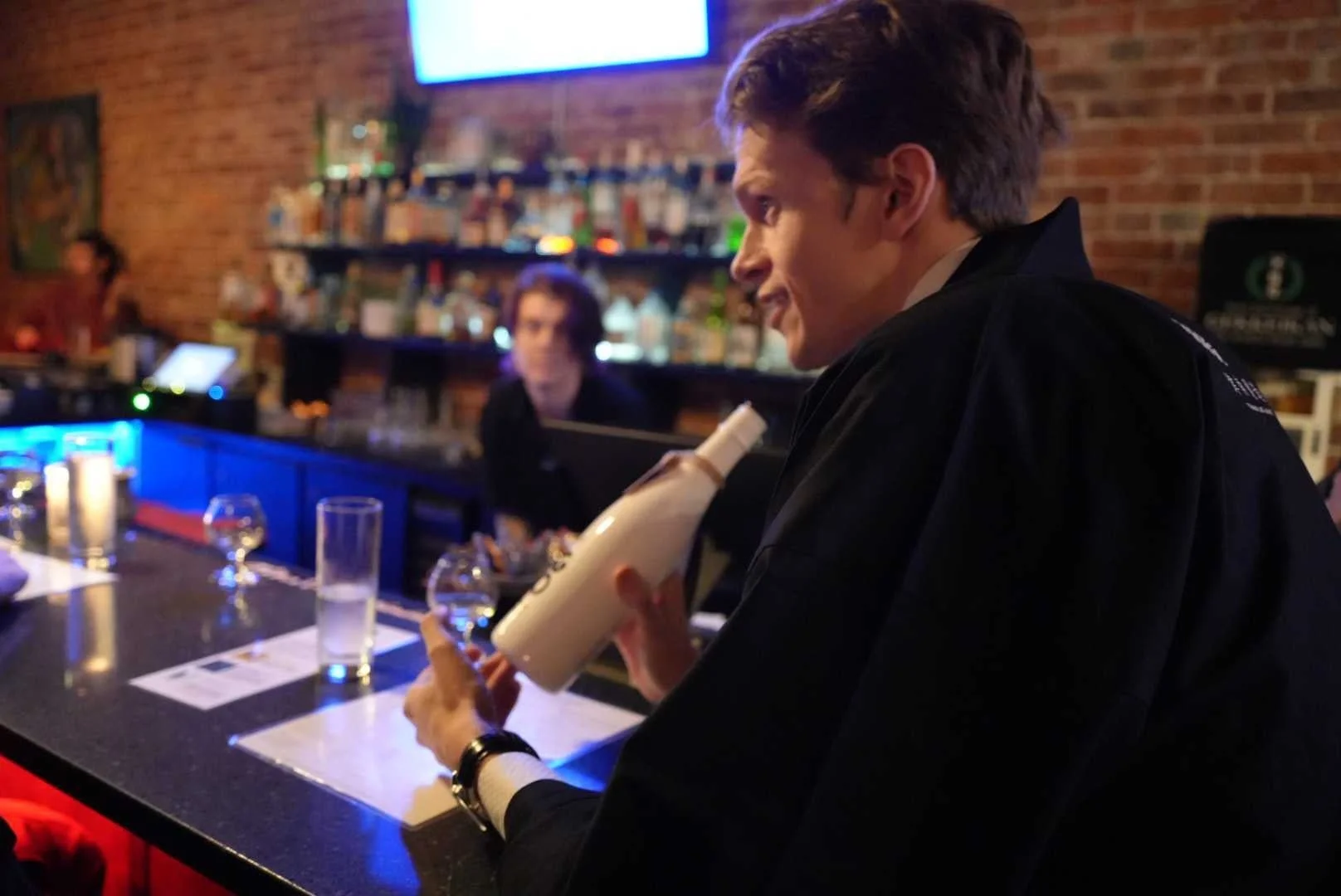 日本酒のボトルを手に説明する様子