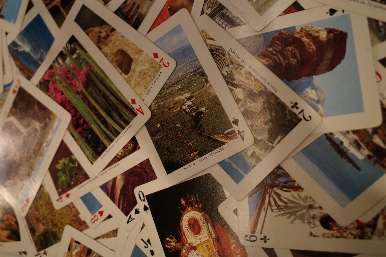 カナリア諸島（グラン・カナリア、テネリフェ、ラス・パルマス）の観光名所がデザインされたトランプが散らばっています。様々な風景や建物が描かれており、旅行の記念品として集められたものと思われます。