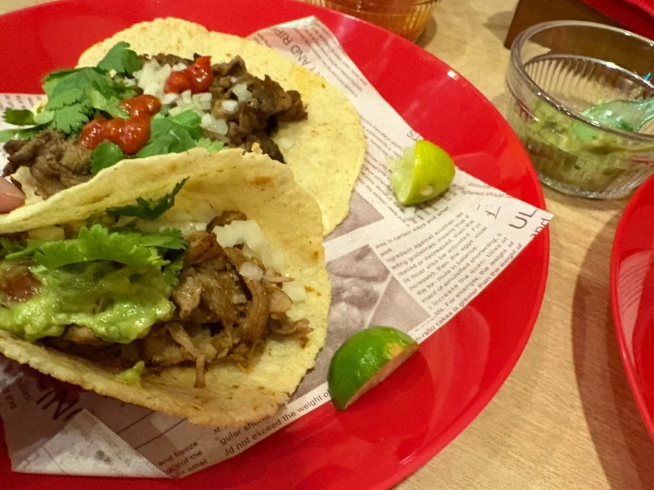 赤い皿に盛り付けられた2つのタコス