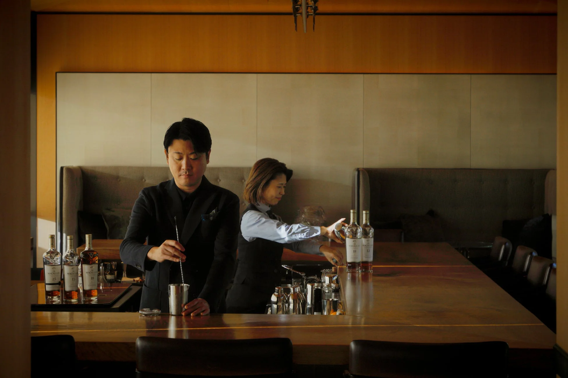 バーカウンターでカクテルを作るバーテンダー