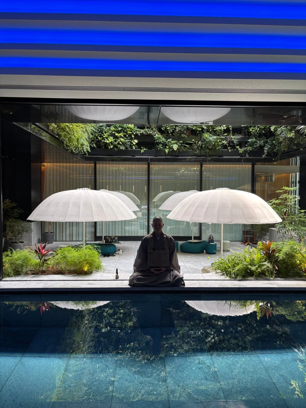 プールサイドで瞑想する僧侶