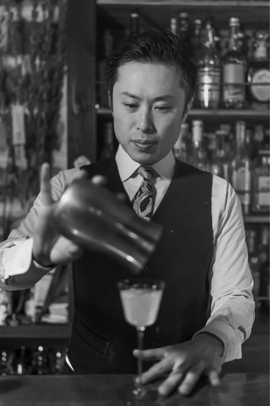 カクテルを注ぐバーテンダー