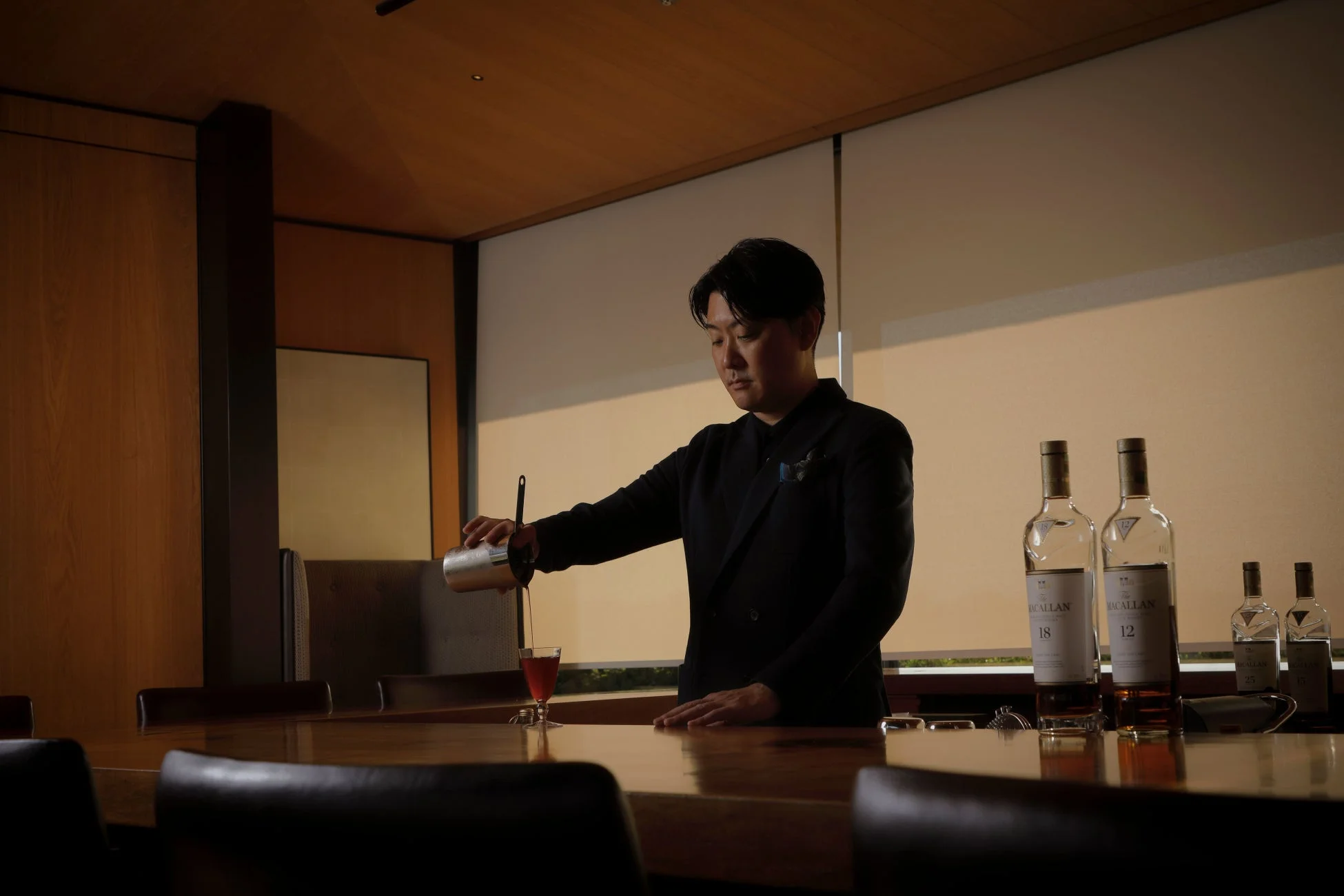 カクテルを注ぐ男性バーテンダー