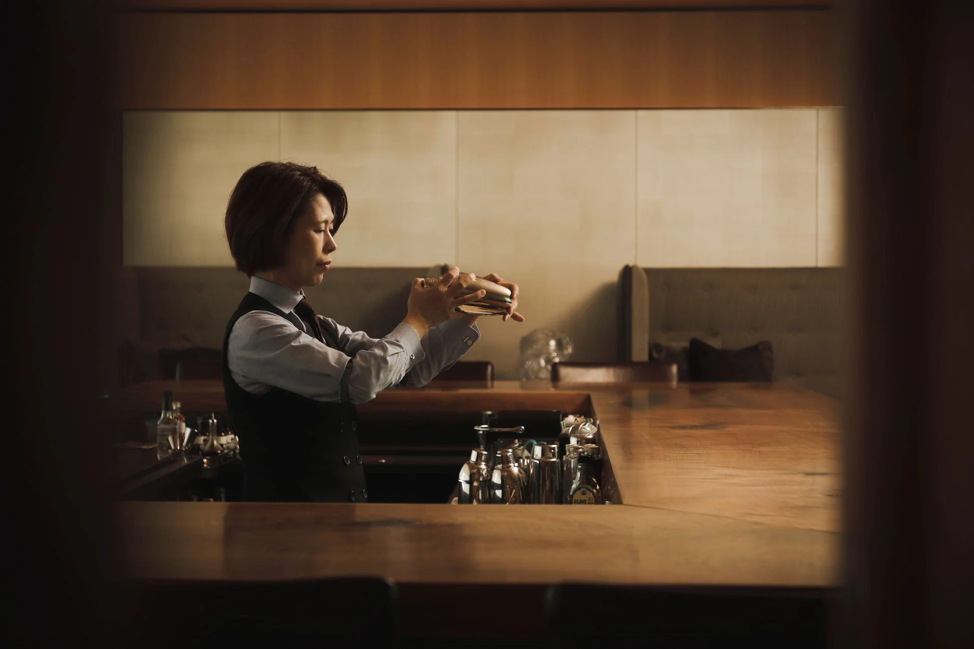 カクテルシェーカーを振る女性バーテンダー