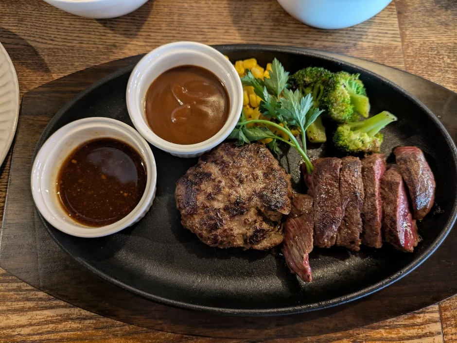 熱々の鉄板に盛り付けられたハンバーグとカットステーキのセット