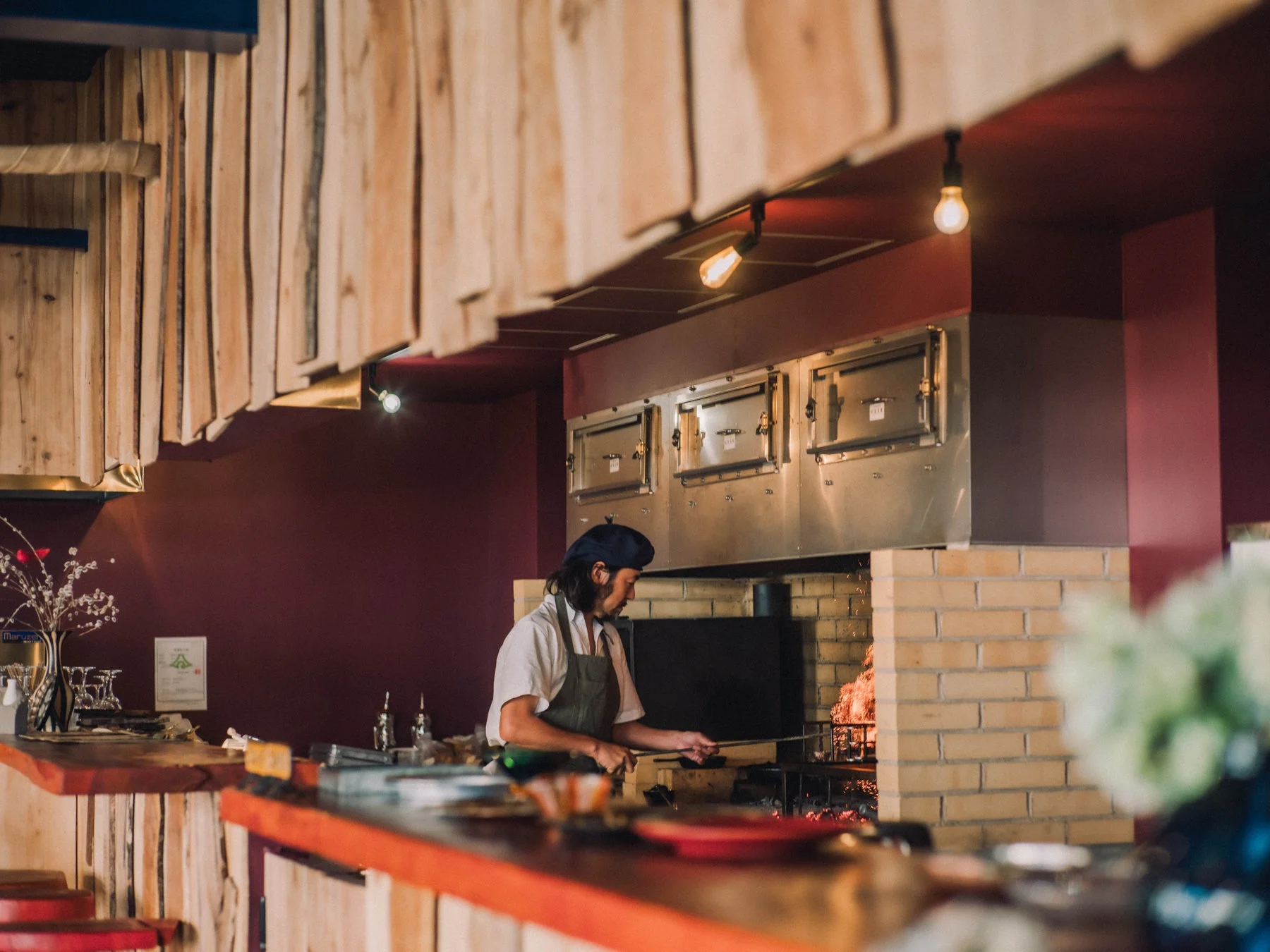 シェフが薪グリルで肉を焼く様子