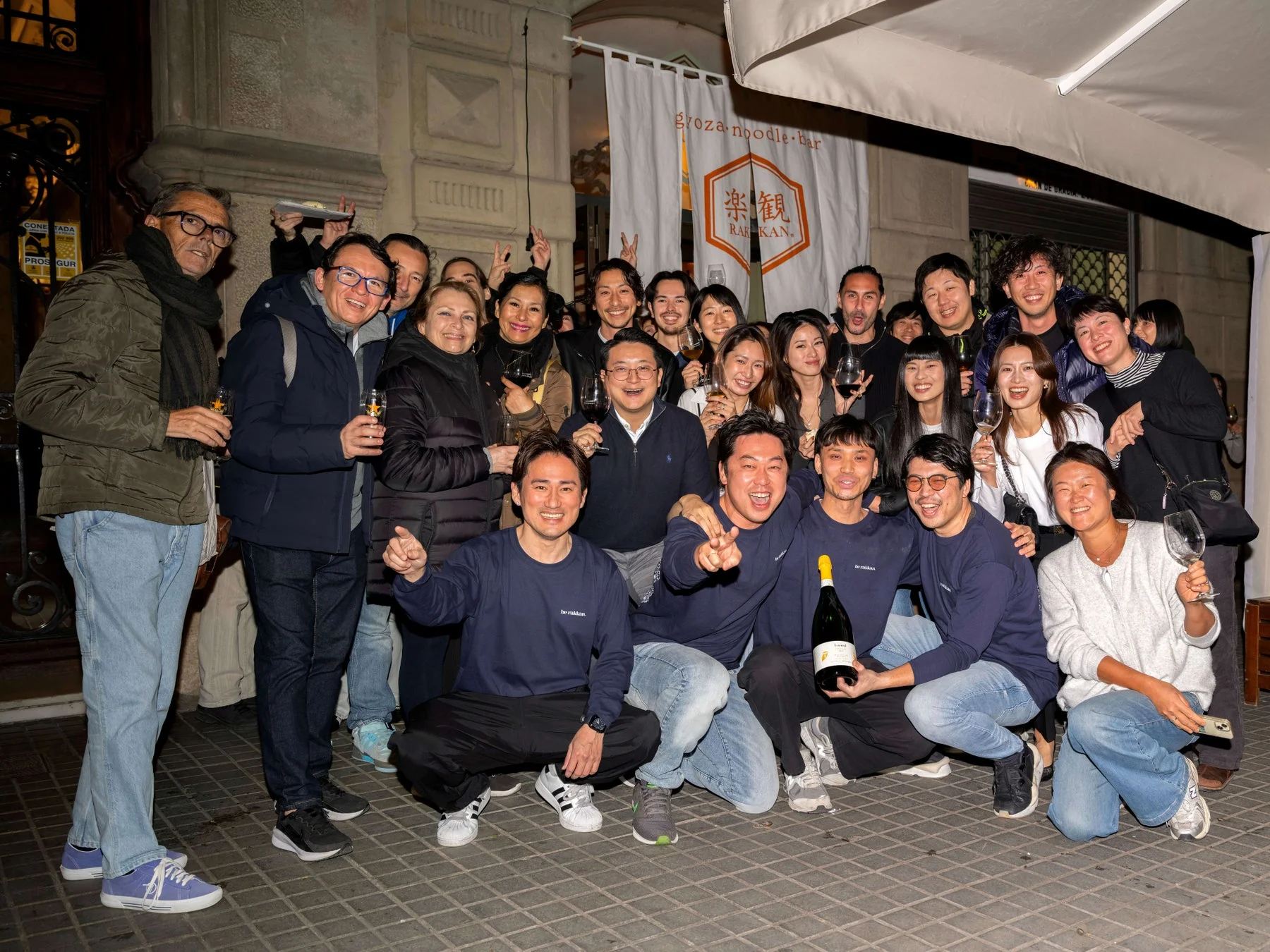 夜のレストラン前で笑顔で集まる人々