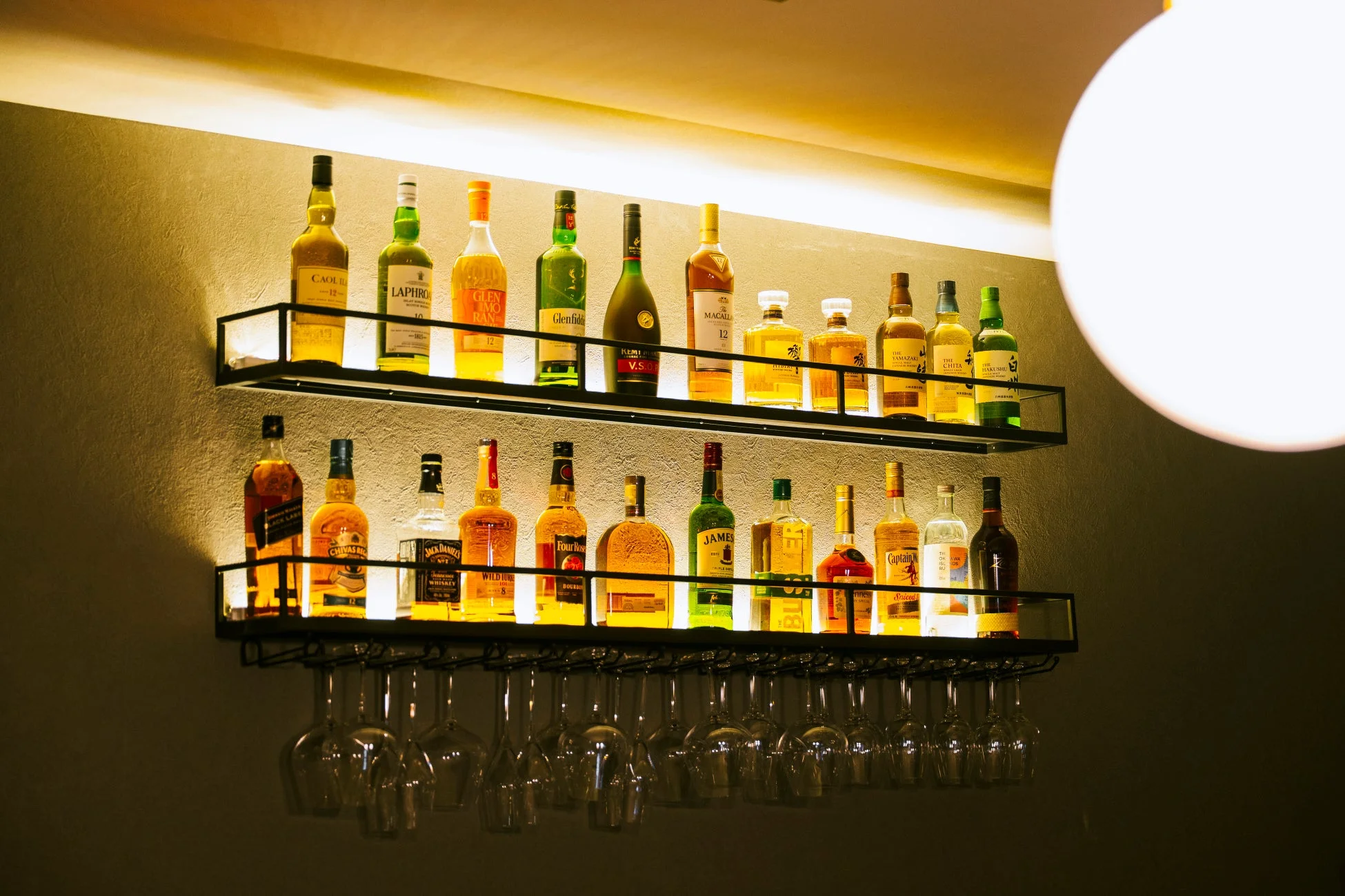 様々な種類のウイスキーやスピリッツのボトルが並ぶバーカウンター