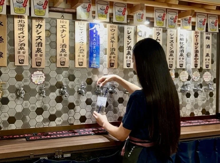 女性が蛇口から飲み物を注いでいる様子