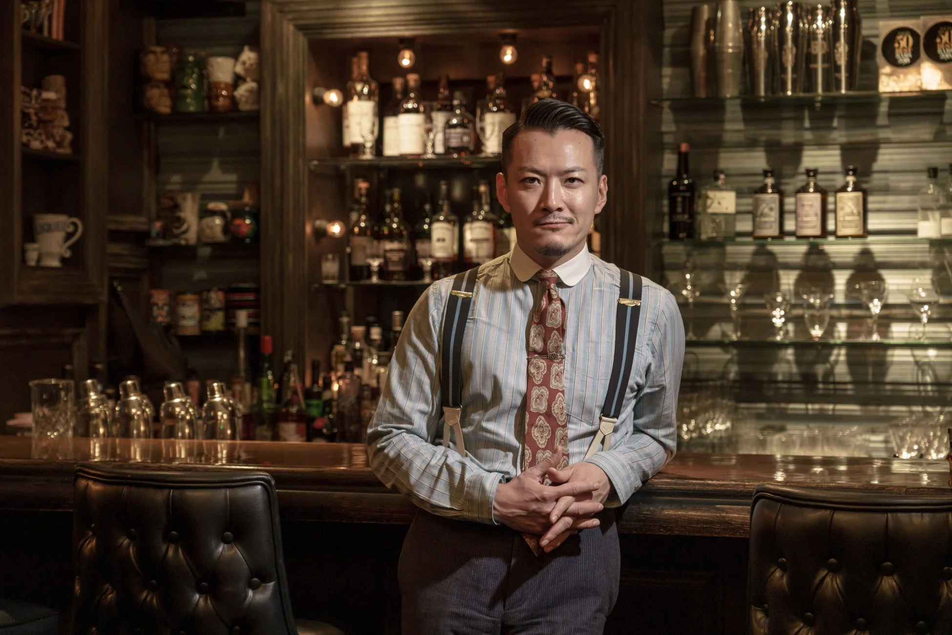 スタイリッシュなシャツとネクタイ、サスペンダーを着用した男性バーテンダー