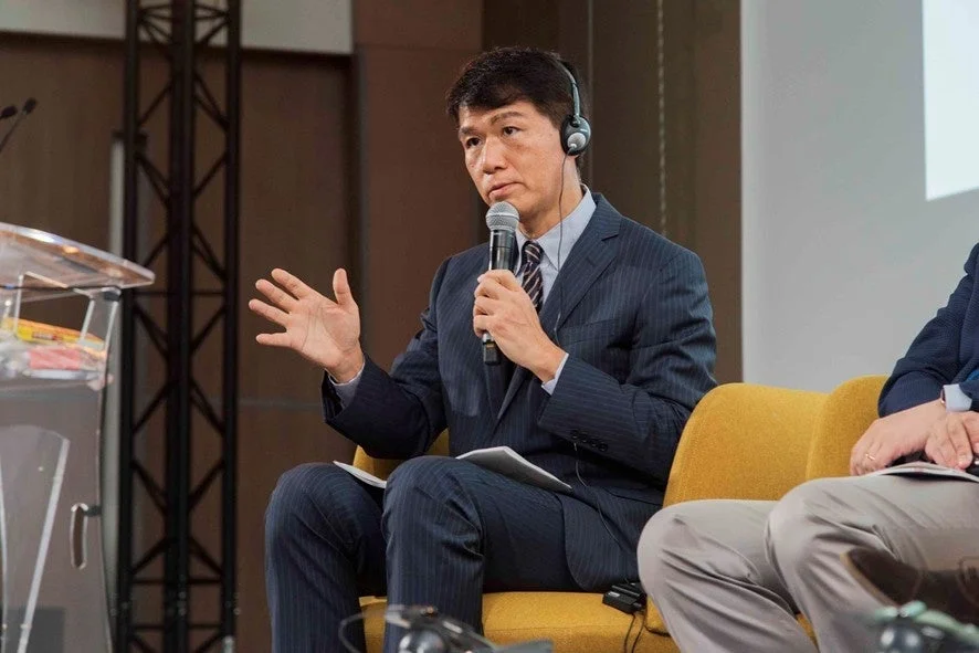 スーツ姿で講演する井上岳久氏