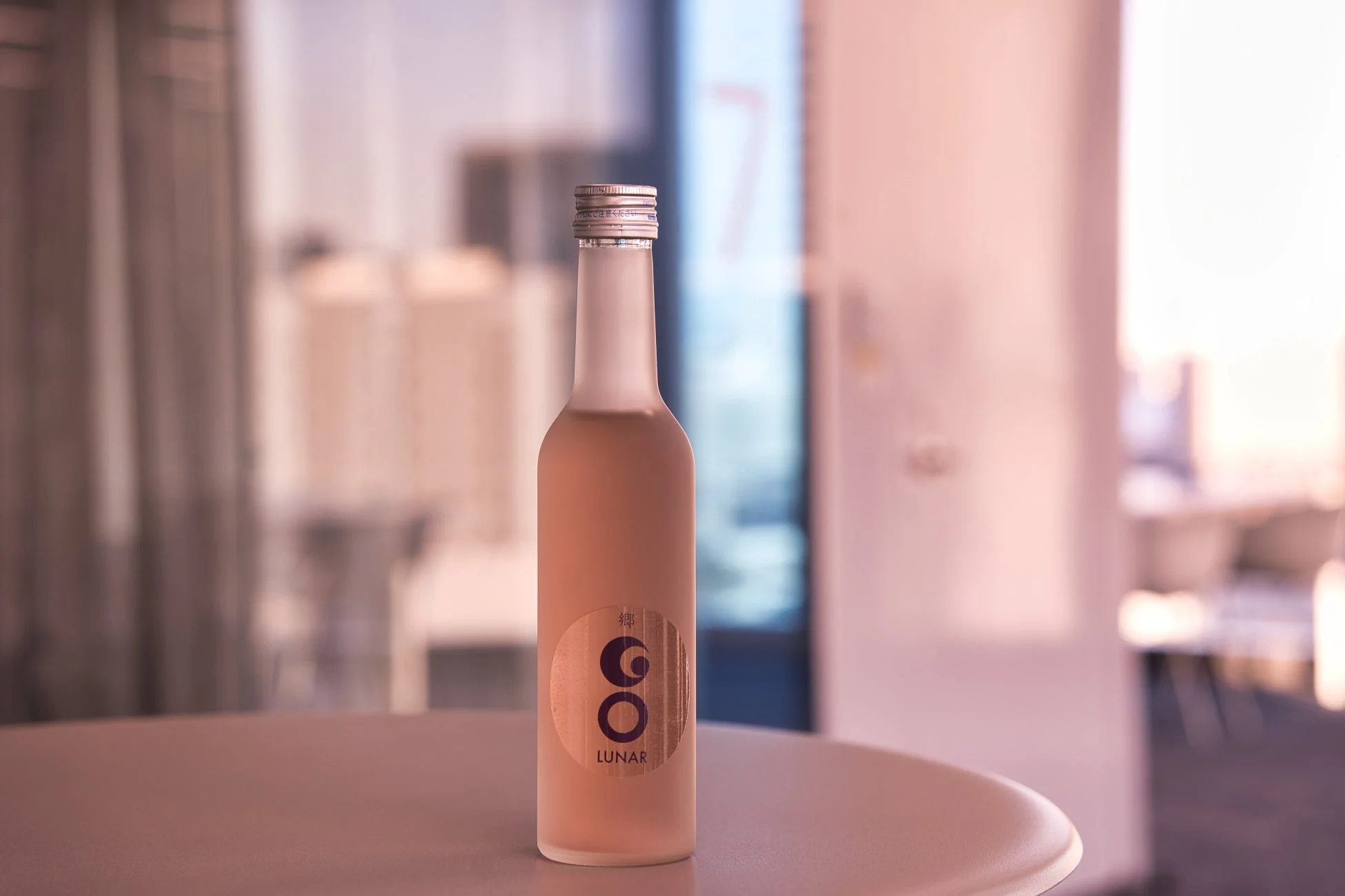 ピンクの液体が入ったすりガラスのボトル