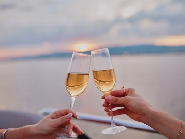 夕暮れ時にシャンパンで乾杯する手元