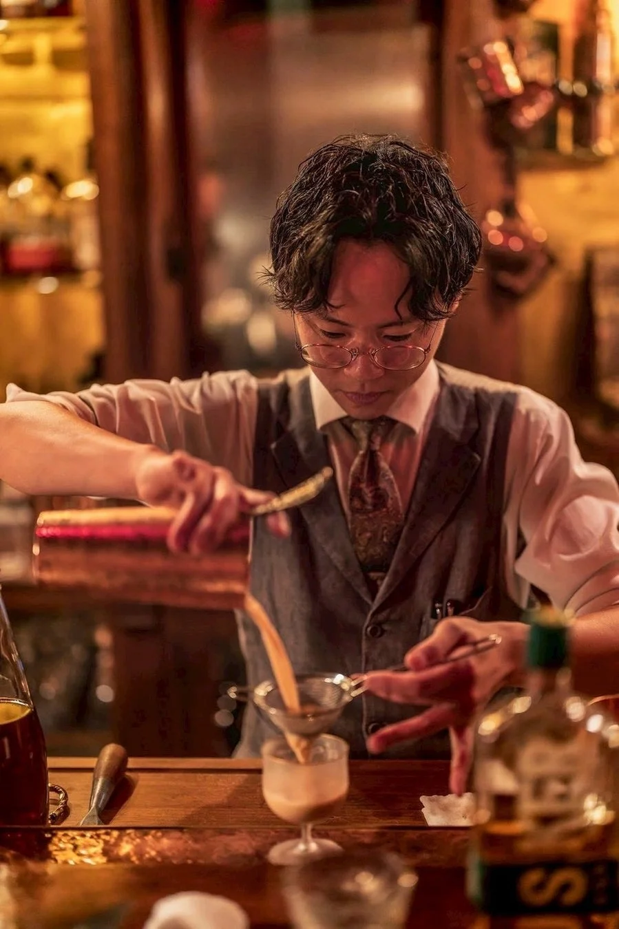 シェーカーからカクテルを注ぐ藤本竜介氏