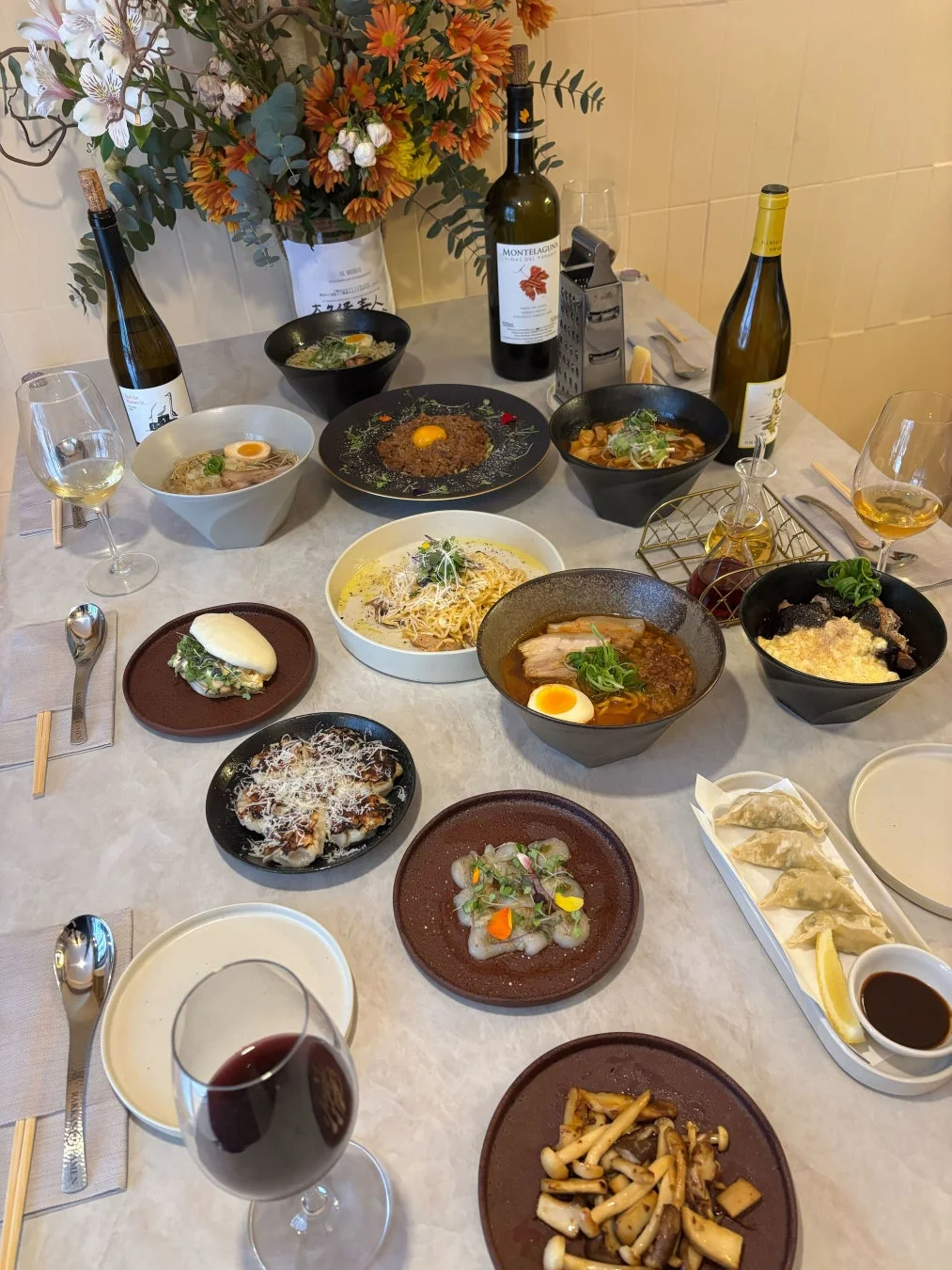 ラーメン、パスタ、餃子など多種多様な料理が並ぶ食卓