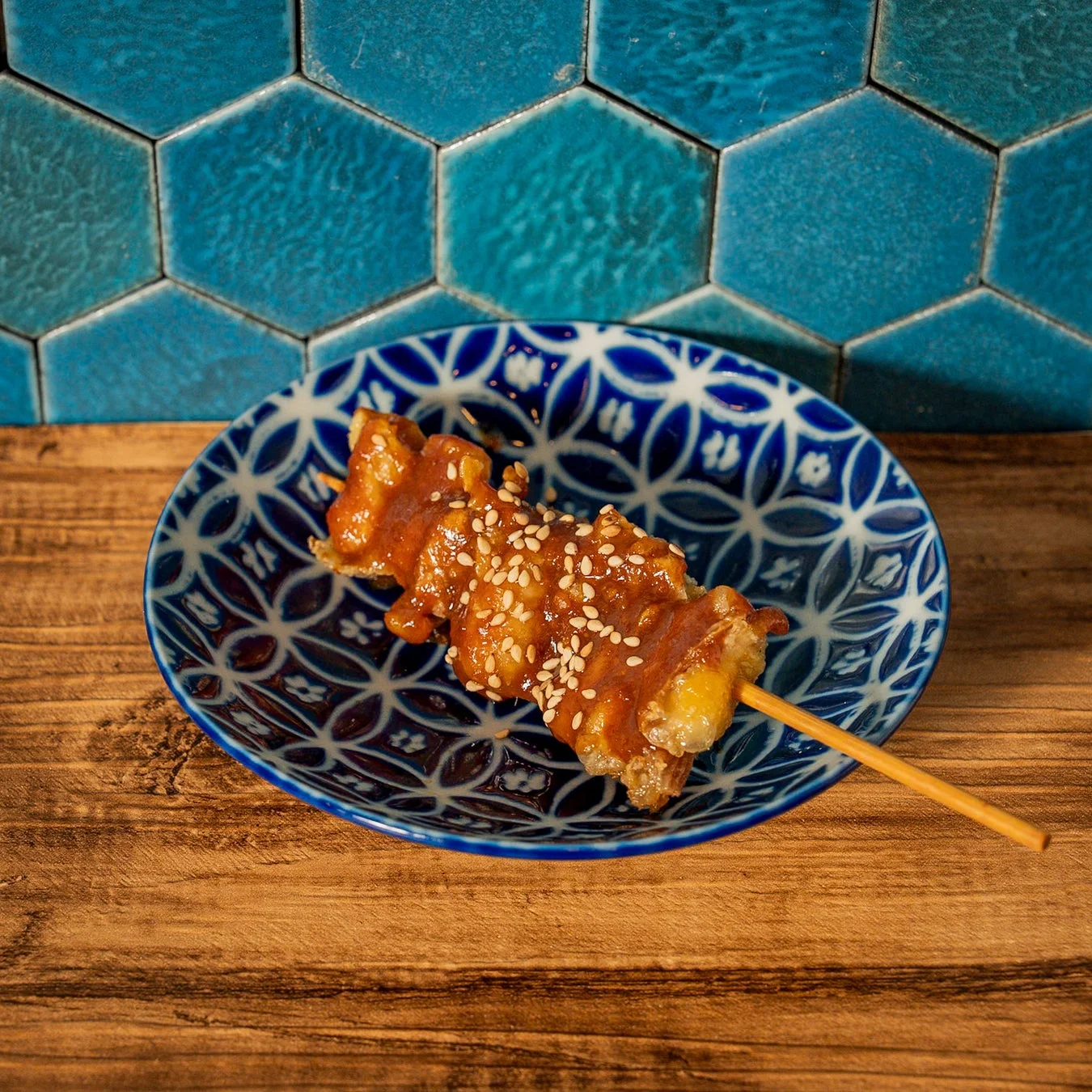 甘辛いタレと白ごまがかかった串料理