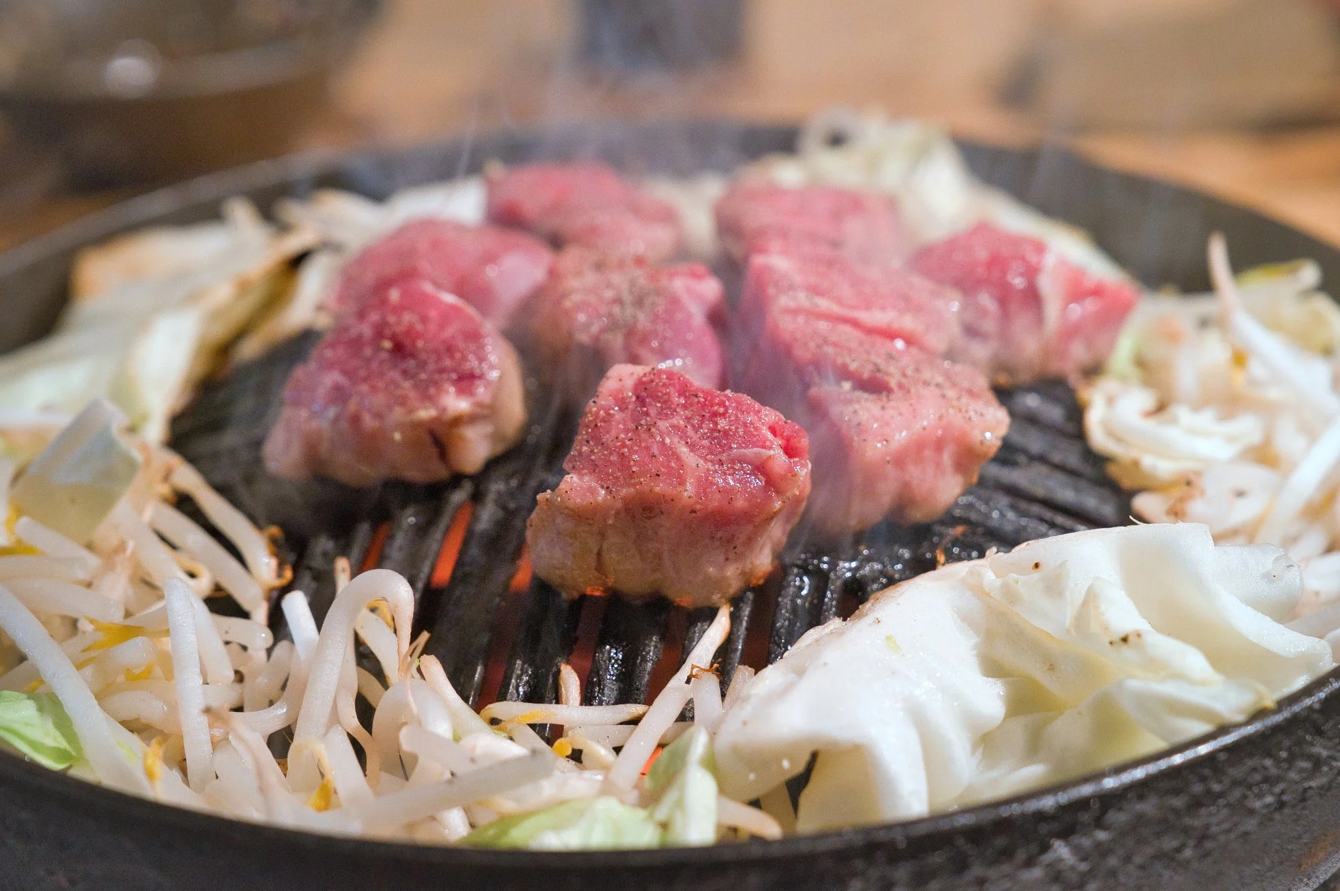 ジンギスカン鉄板で焼かれる肉と野菜