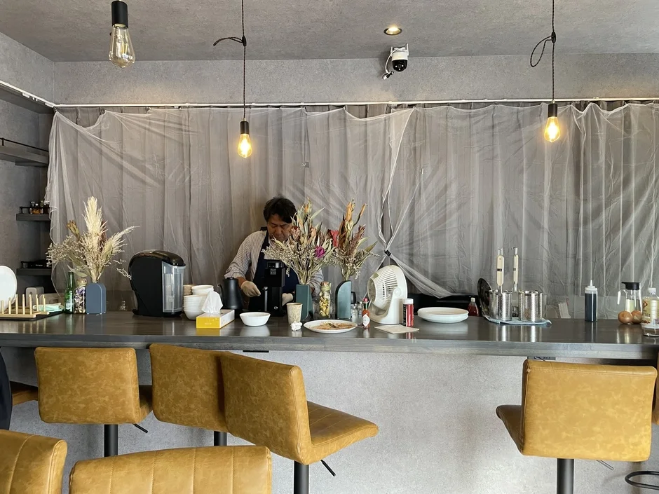 カフェのバーカウンターで調理する男性