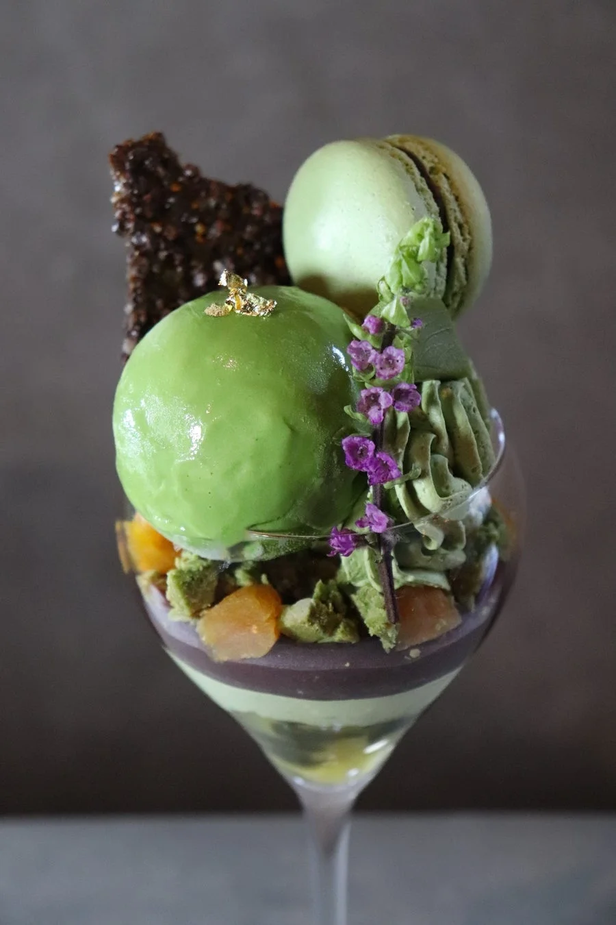 ワイングラスに入った抹茶を基調とした豪華なパフェ
