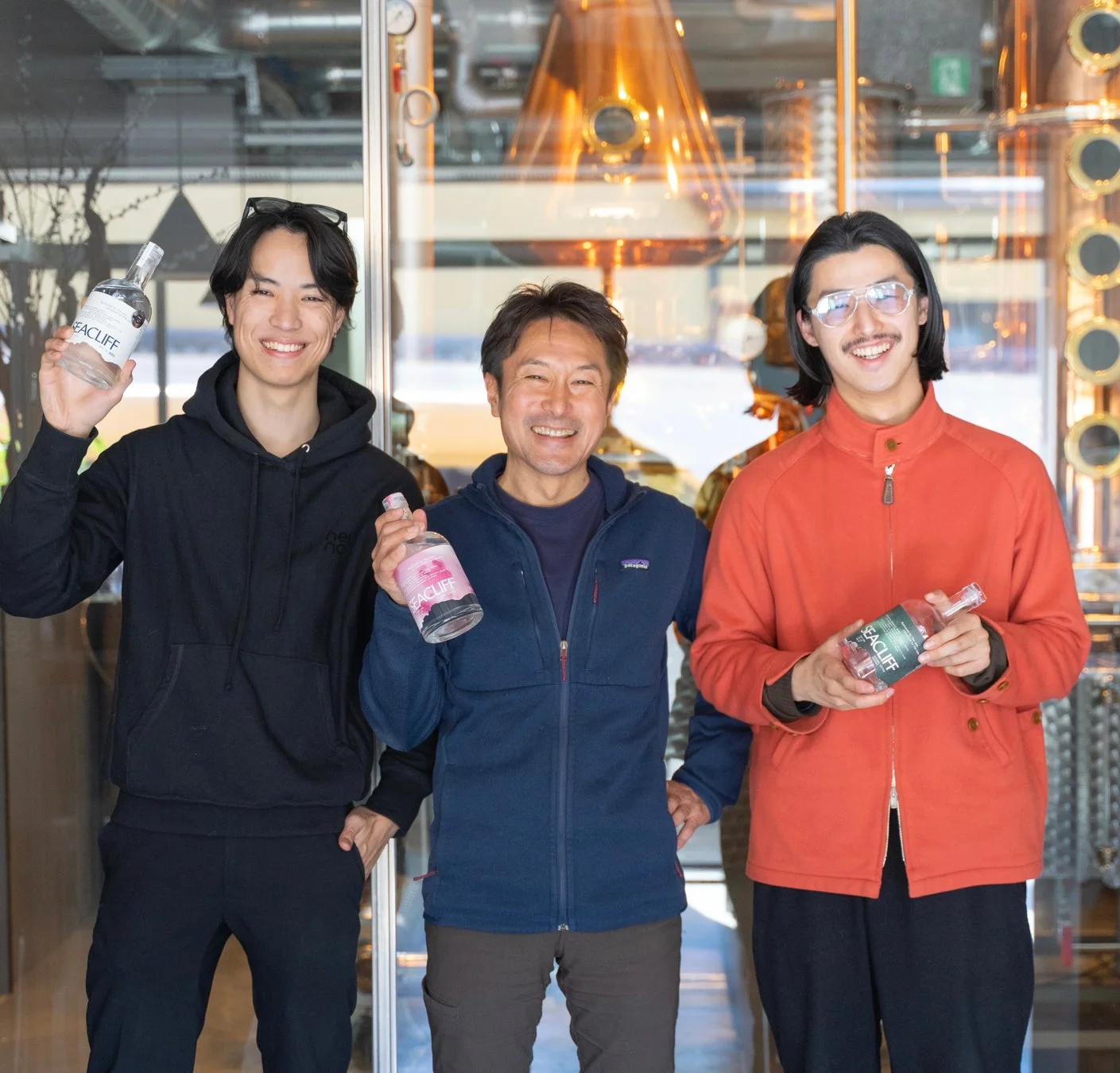 3人の男性がジンボトルを持つ