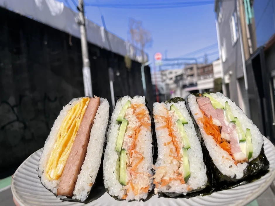 スパムと卵焼き、ツナマヨ、ハム、きゅうり、にんじんなど、彩り豊かな具材が挟まれたおにぎらず
