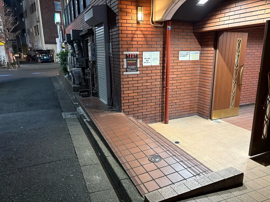 夜の日本の街角にあるレンガ造りの建物の入り口です。
