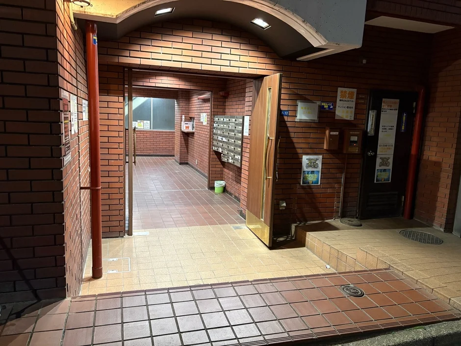 夜間のマンションのエントランスを捉えた画像です。