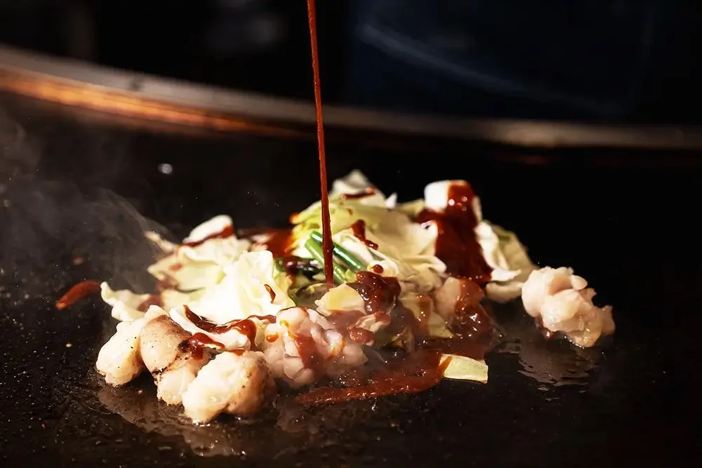 調理中のホルモンとキャベツ