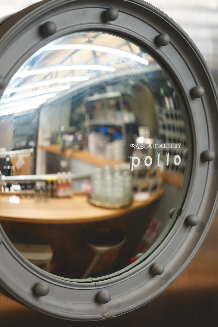 円形の窓ガラスに店内の様子が反射して映り込んでいる