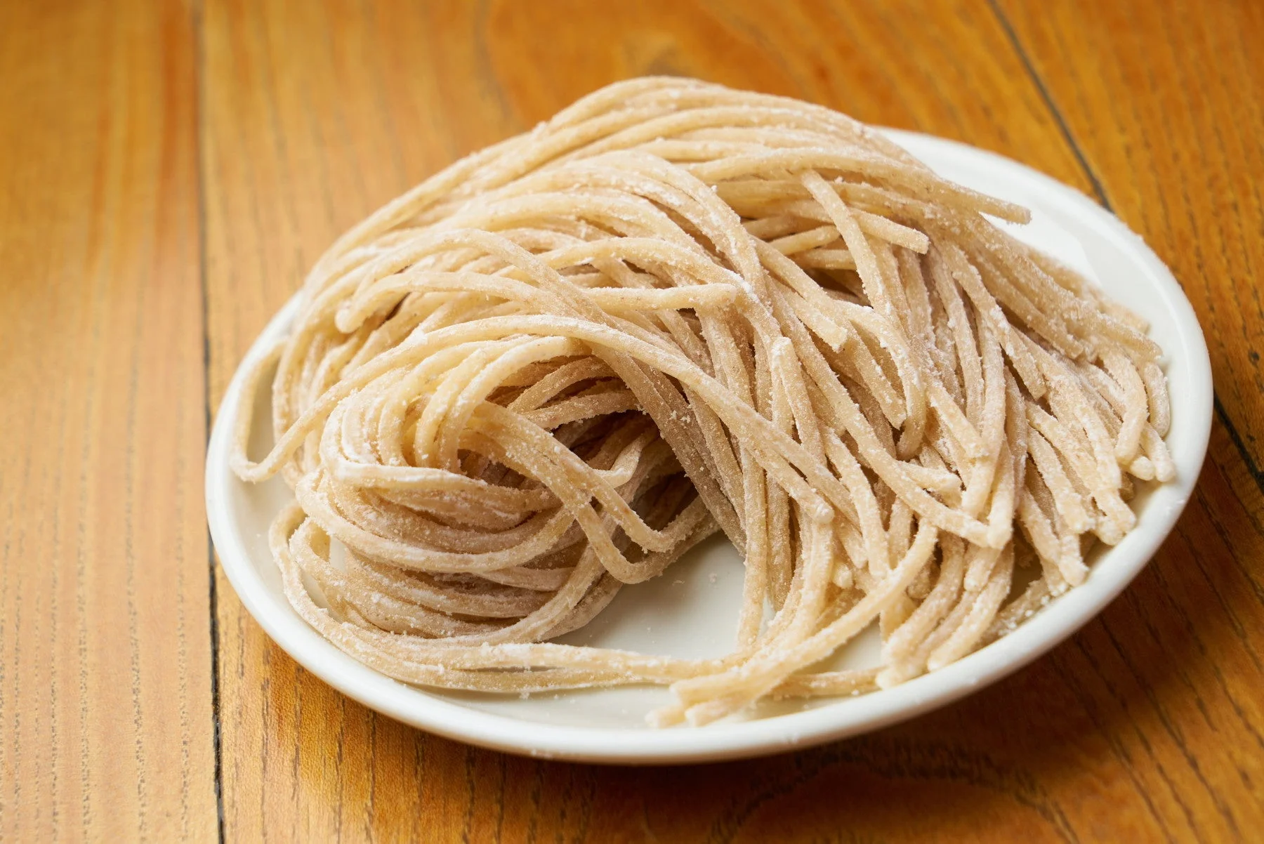 白い皿に盛られた未調理の生麺