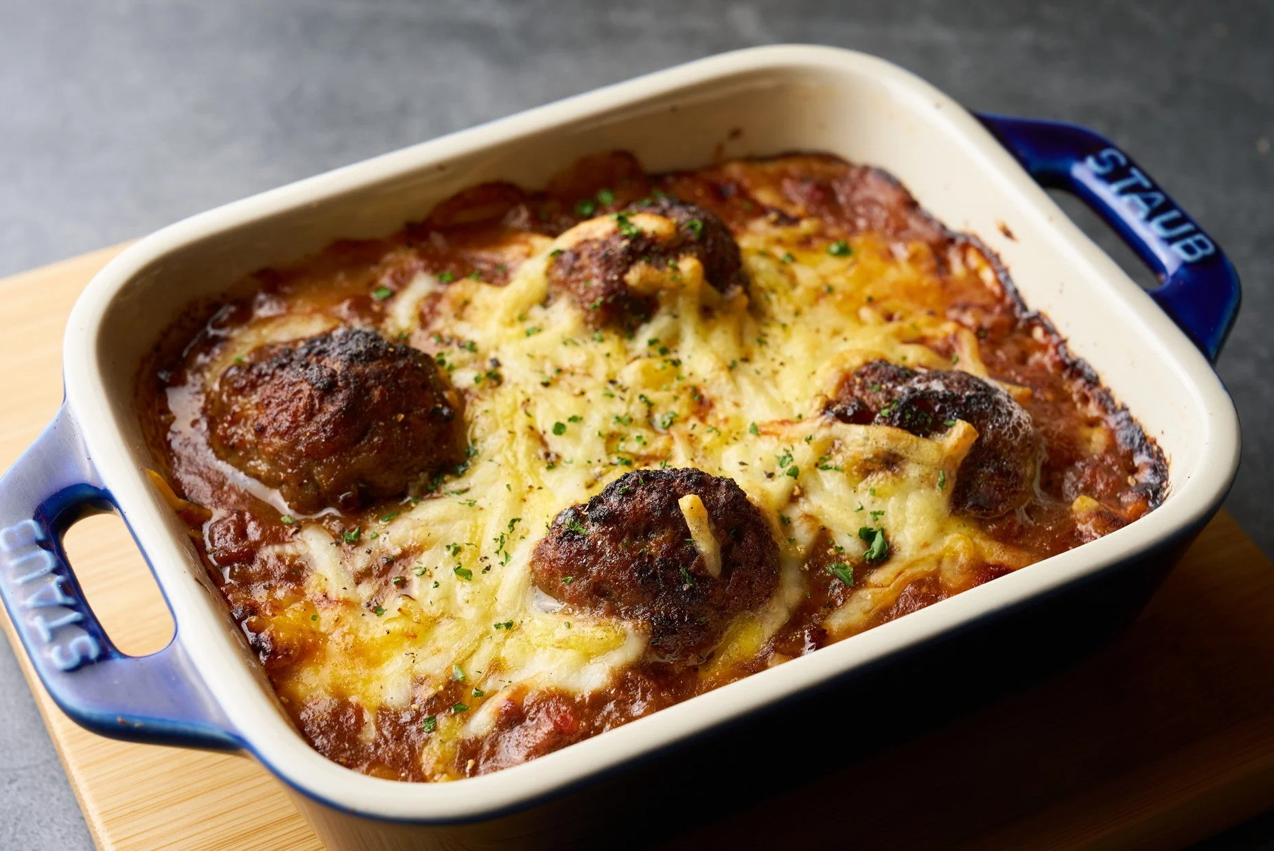 青いSTAUBの耐熱皿に入ったミートボールのチーズ焼き