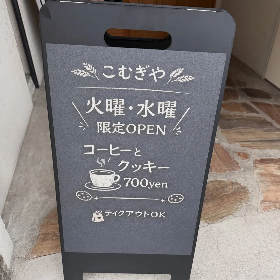 「こむぎや」のA型看板。火曜・水曜限定でオープンし、コーヒーとクッキーのセットを700円で提供。テイクアウトも可能