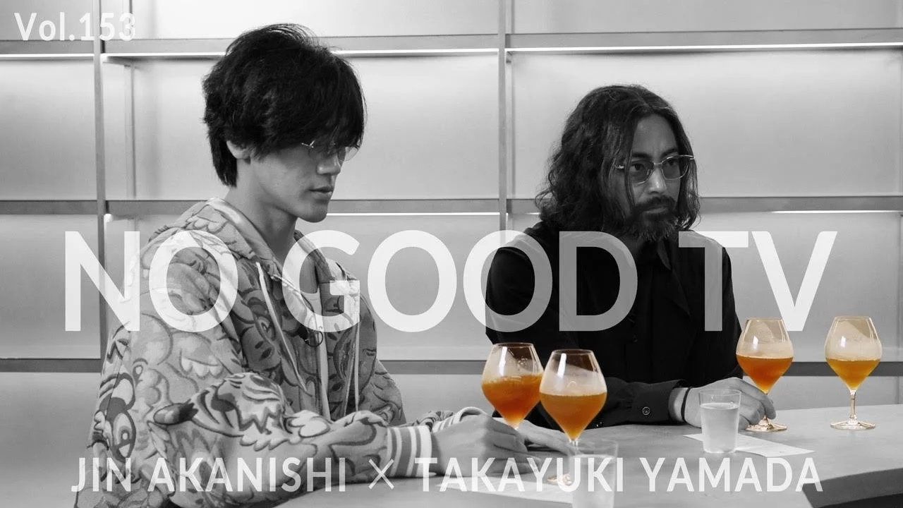 白黒の画面で、赤西仁と山田孝之がテーブルを挟んで向かい合い、飲み物を片手に「NO GOOD TV Vol.153」に出演している様子