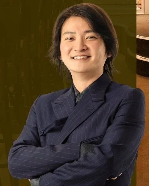 ストライプのスーツを着用し、腕組みをして笑顔を見せる林尚弘氏のポートレート