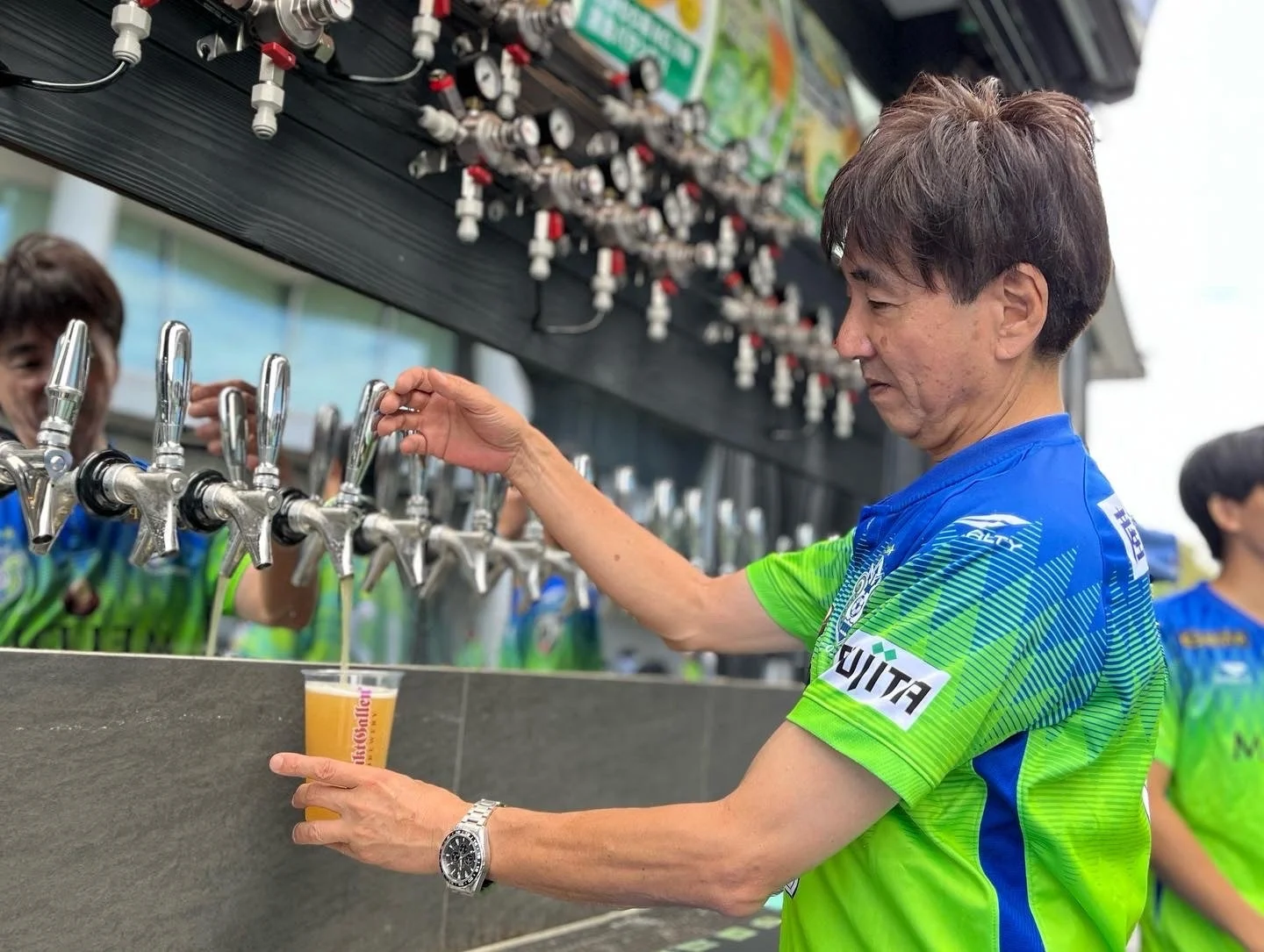 屋外イベントでビールを注ぐ男性