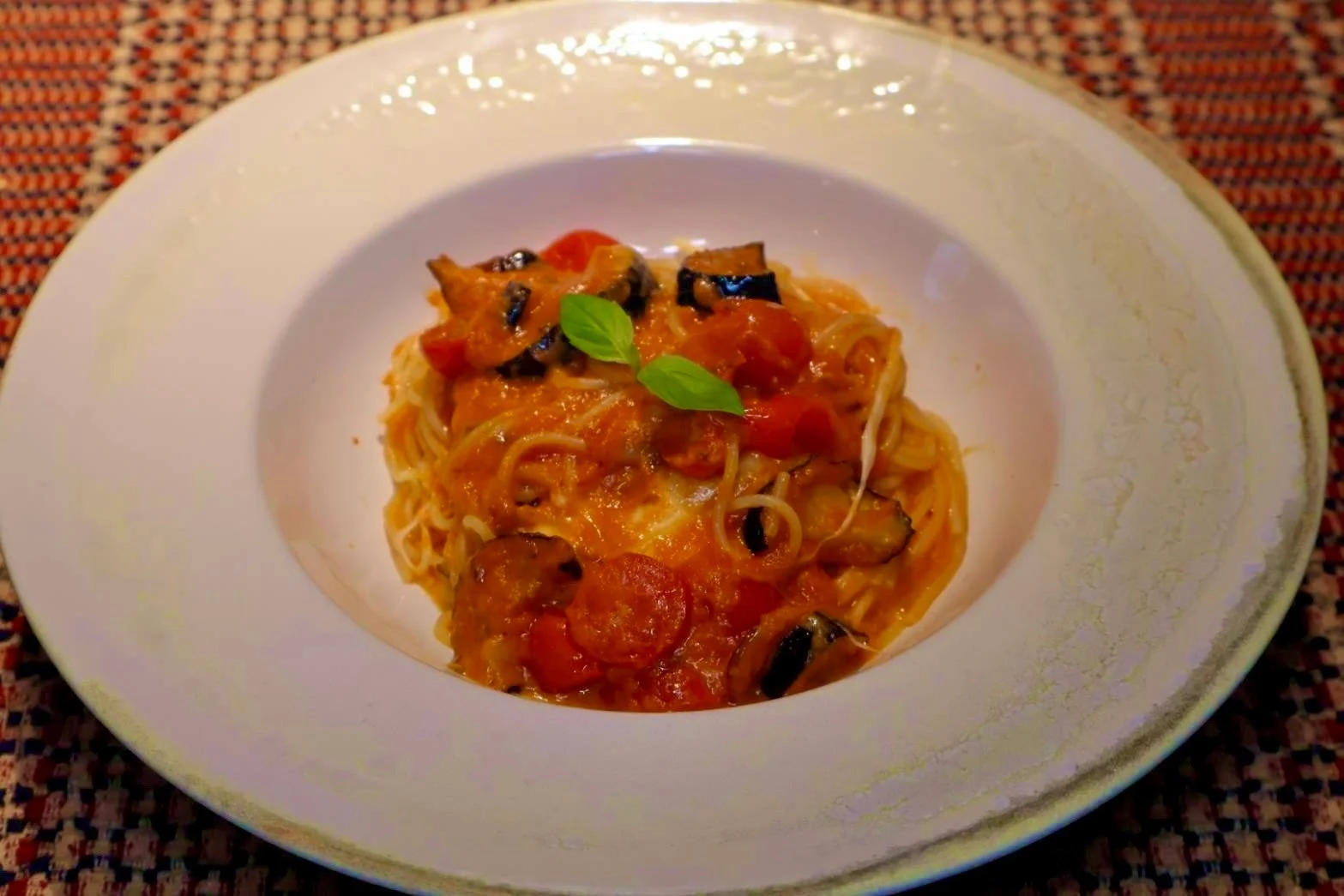白皿に盛られたナスとトマトのパスタ