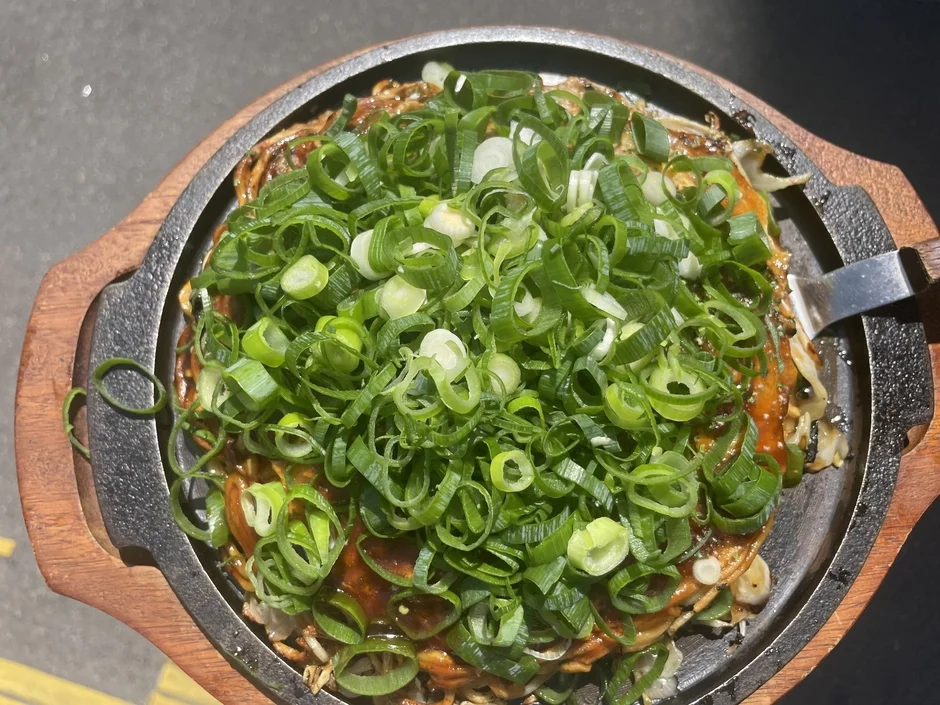 鉄板に乗ったネギたっぷりの焼き料理