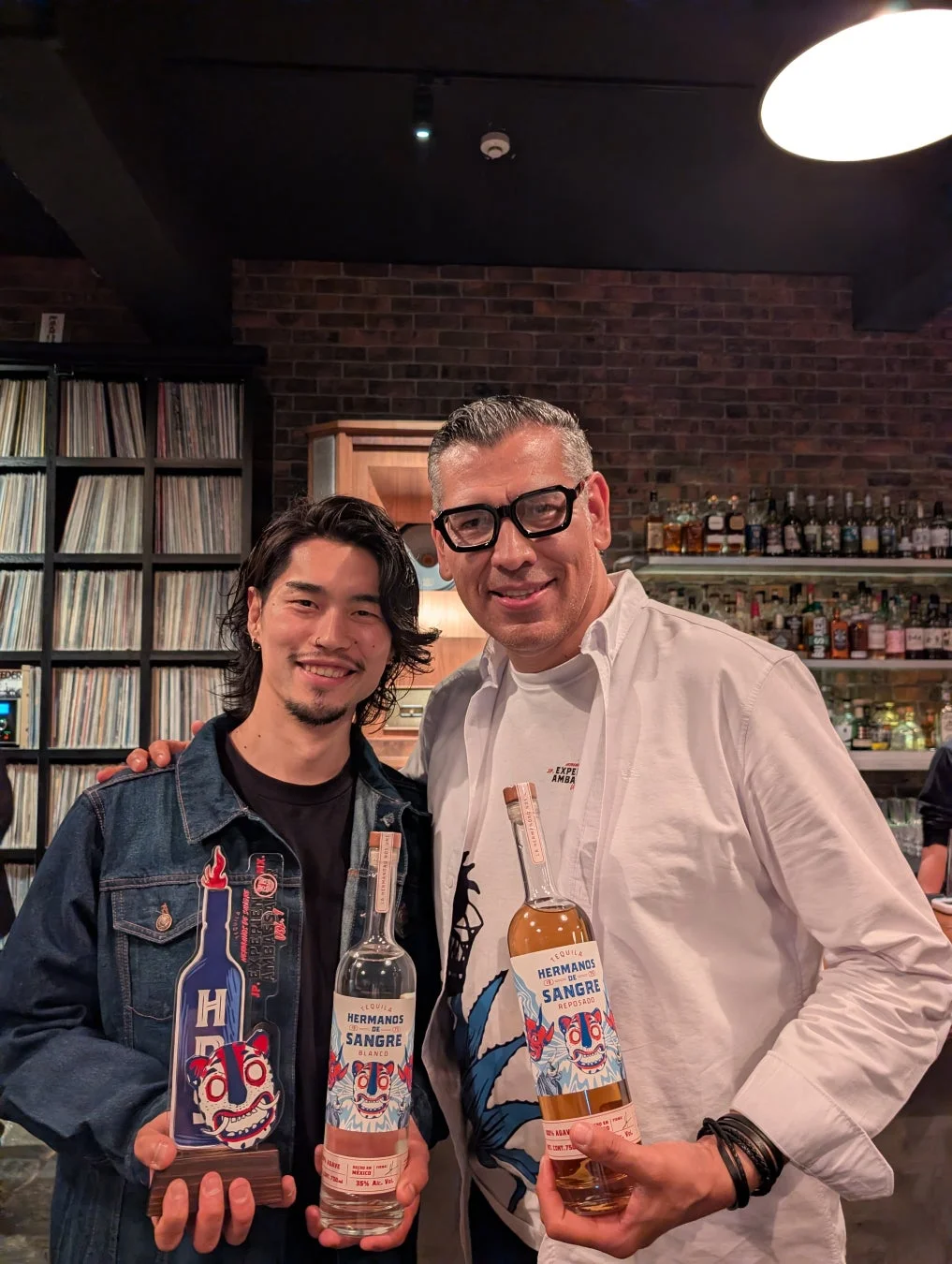 テキーラボトルを手に笑顔の陣野さんとオーナー