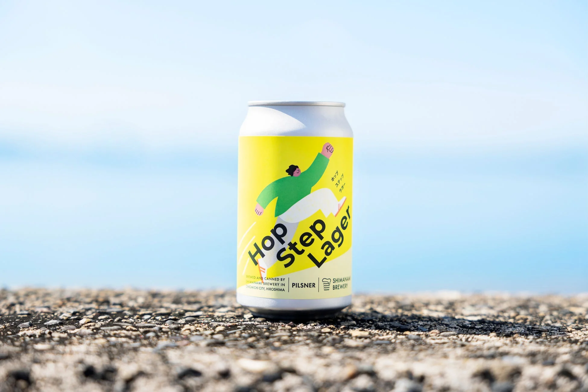 青空を背景に置かれたHop Step Lagerのビール缶
