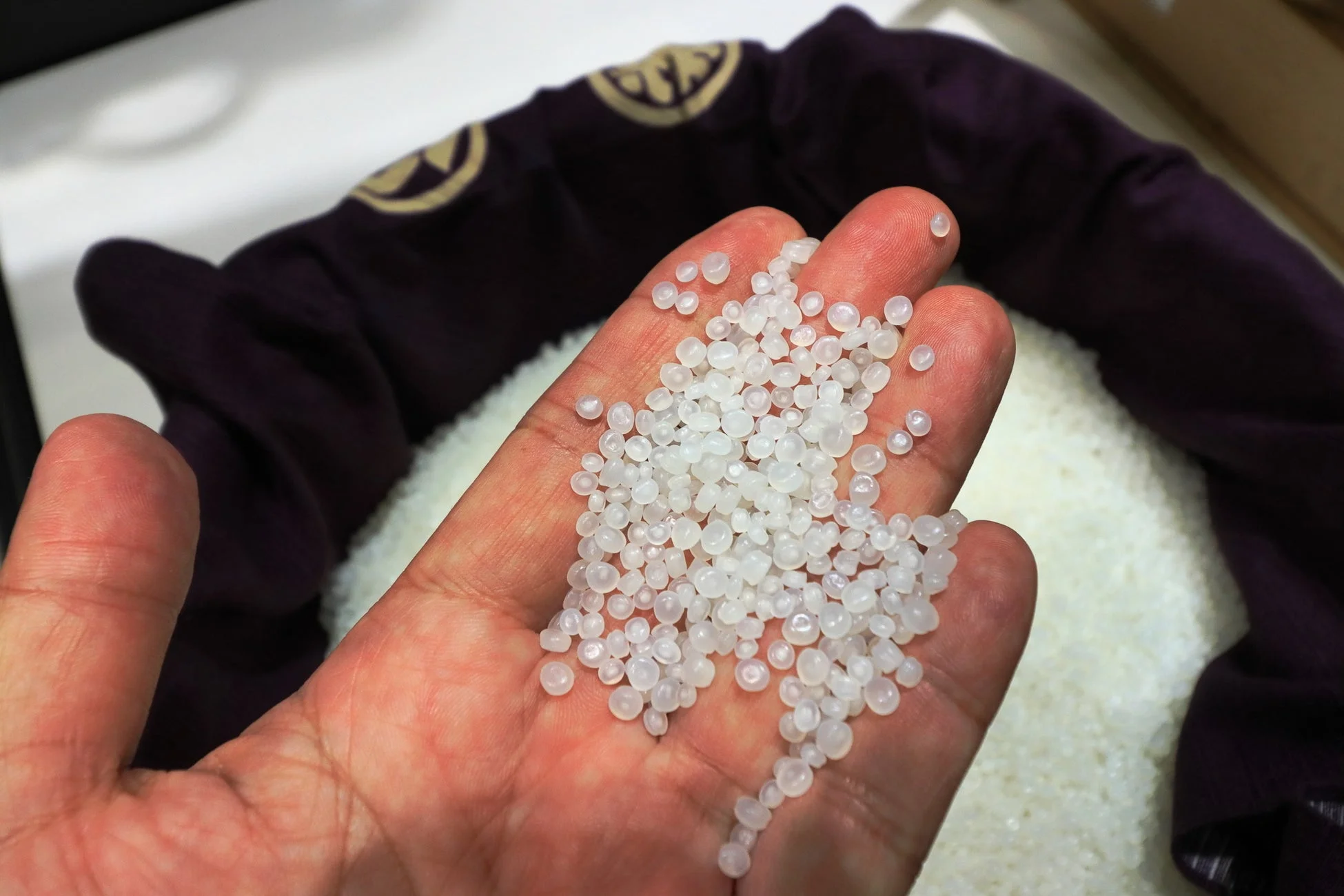 手のひらに乗せられた白いプラスチックペレット