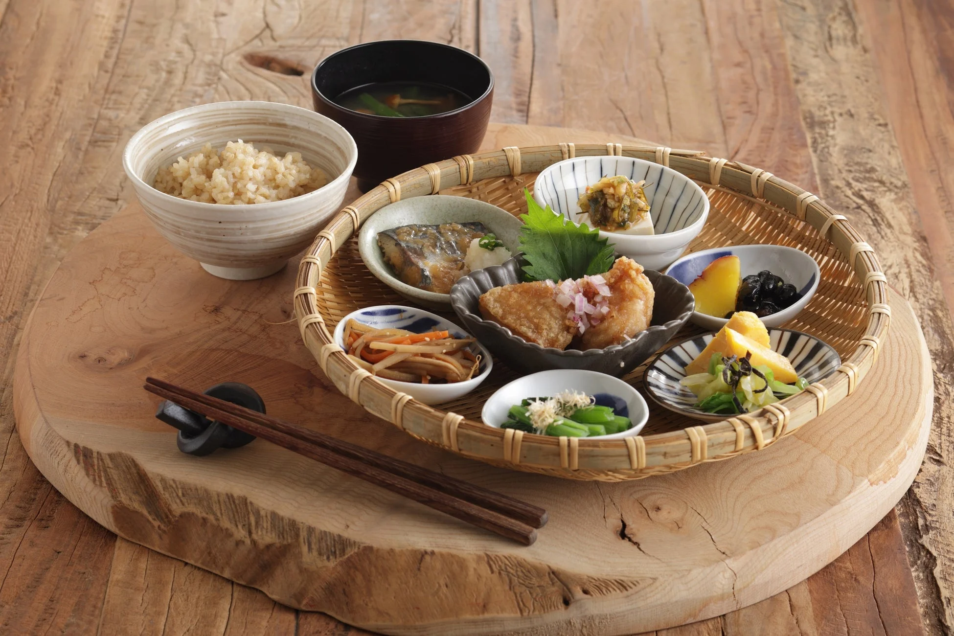 玄米ご飯、味噌汁、焼き魚、唐揚げなど多彩な小鉢が並ぶ和定食